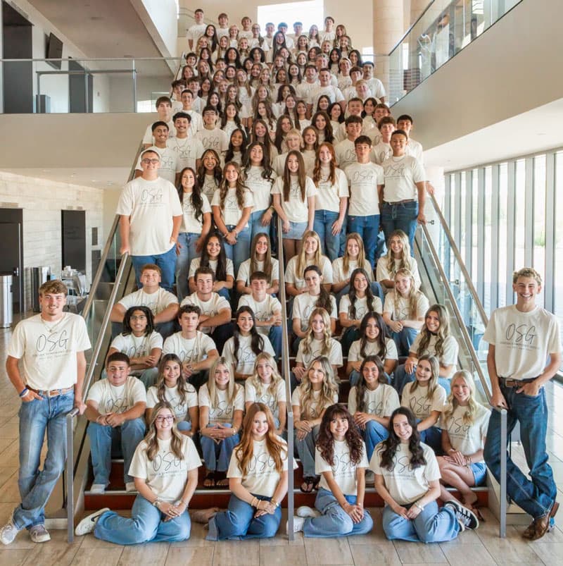 Belles and Beaux gathered together on a staircase for their new program year